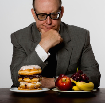 man looking at doughnuts and fruit weight loss for men over 40