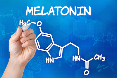 Hand with pen drawing the chemical formula of melatonin
