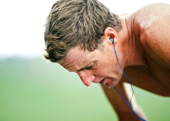 man working out with ear buds stress hacks