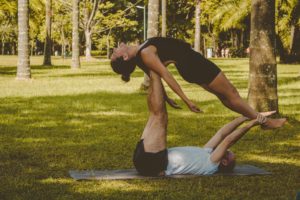 man and woman doing yoga in park as a weight loss workout