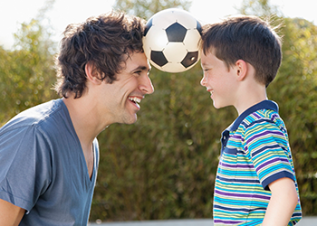 uomo e figlio che giocano a calcio si divertono con la tua dieta e piano di esercizio