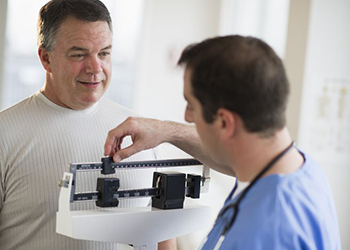 doctor weighing man sleep and weight loss