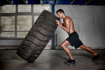 man flipping tire supermans exercise