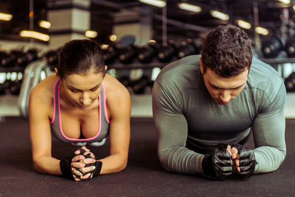 man and woman doing the plank oblique crunches