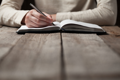 man writing in journal motivation for men