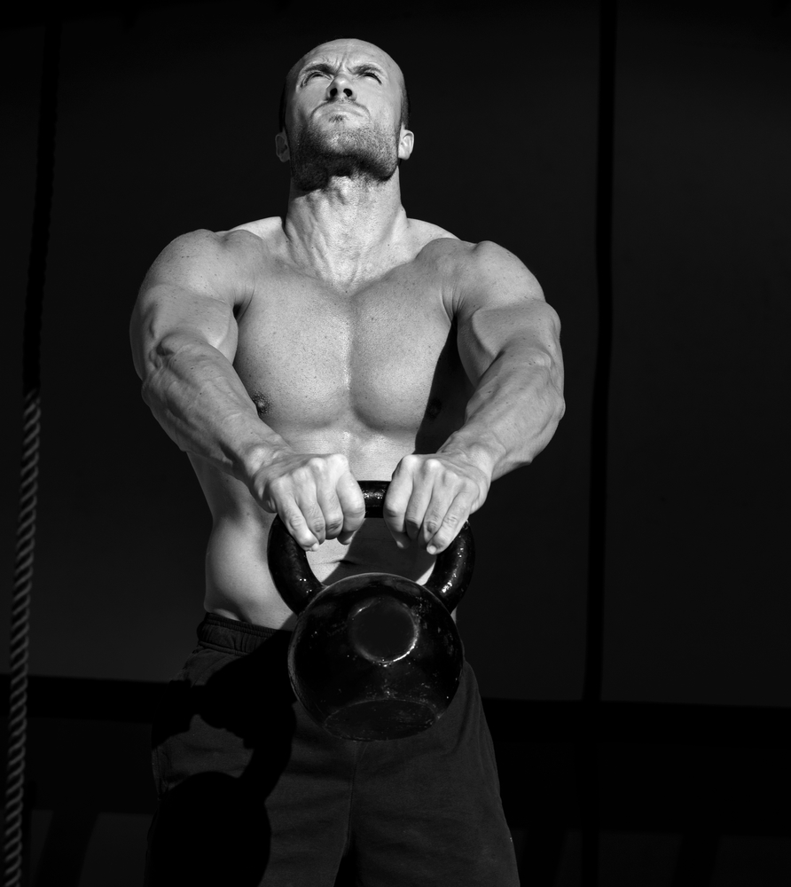 man lifting kettlebell best weight loss programs
